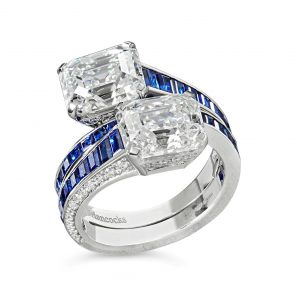 A 3.18ct and 3.04ct emerald-cut diamond and calibre sapphire cross over ring set in platinum £120,000